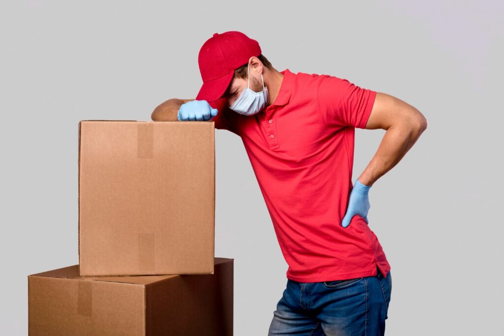 imagem de entregador se apoiando em caixas com dores nas costas